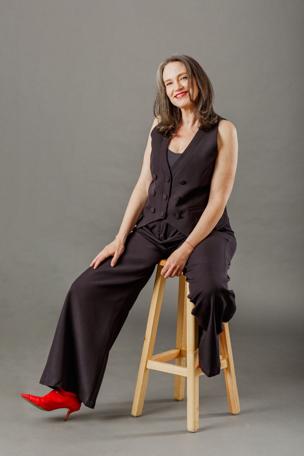 Retrato de Valeria Stoopen sentada, con sus zapatos rojos