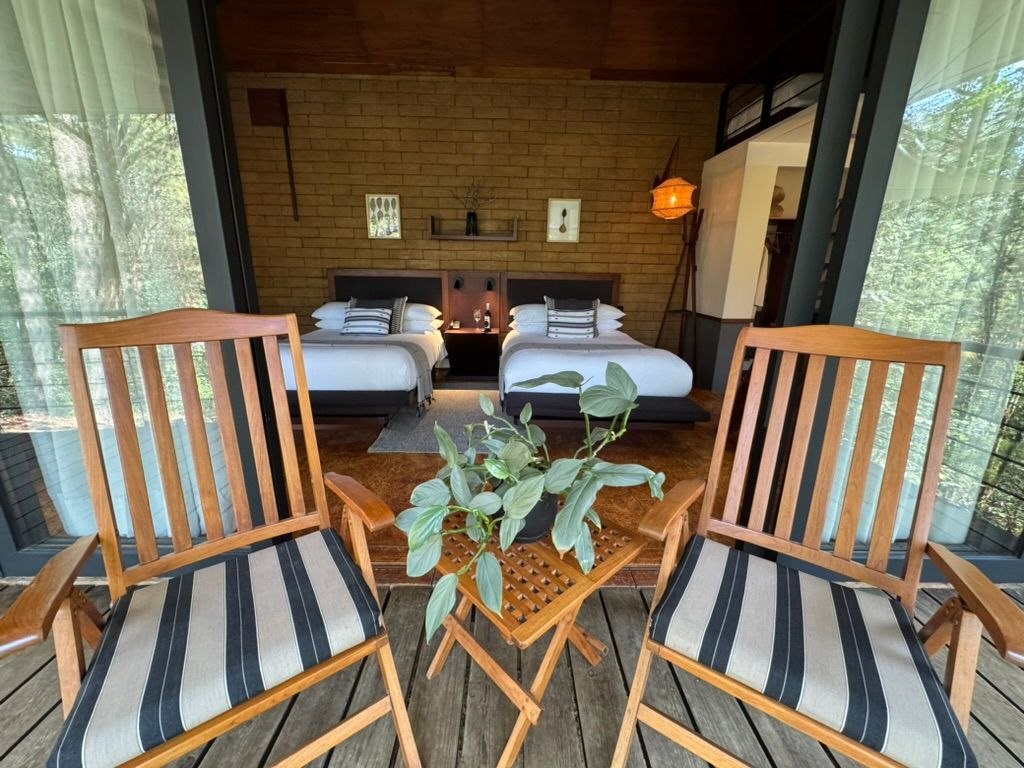 Habitación de Rodavento con dos camas y terraza frente al bosque